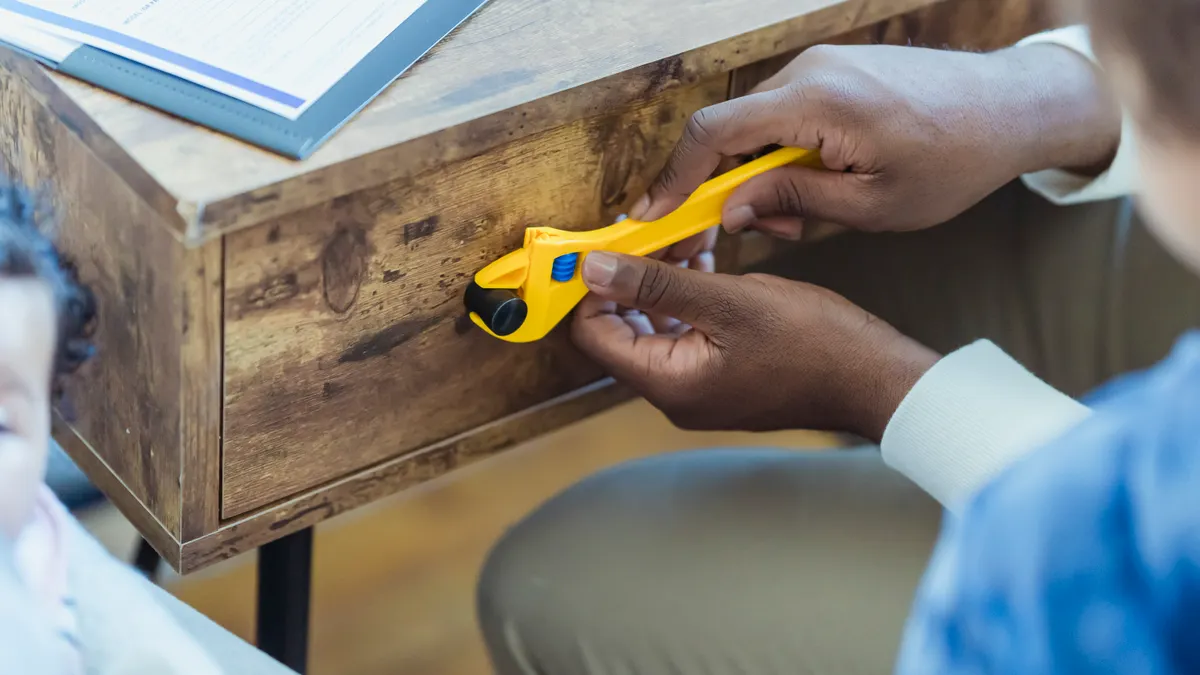 adult installing a child safety lock on a drawer